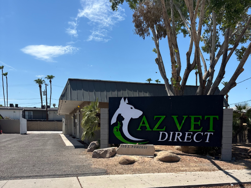 A veterinary clinic building with a large sign reading “AZ Vet Direct,” featuring a dog and cat logo, located at 120 S. Pomeroy with clear skies and desert landscaping – Mobile Vet Phoenix